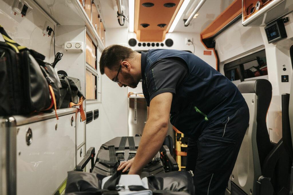 Ambulancier préparant du matériel de premiers soins pour le transport de patient dans une ambulance pour une intervention dans l'Ain ou en Haute-Savoie