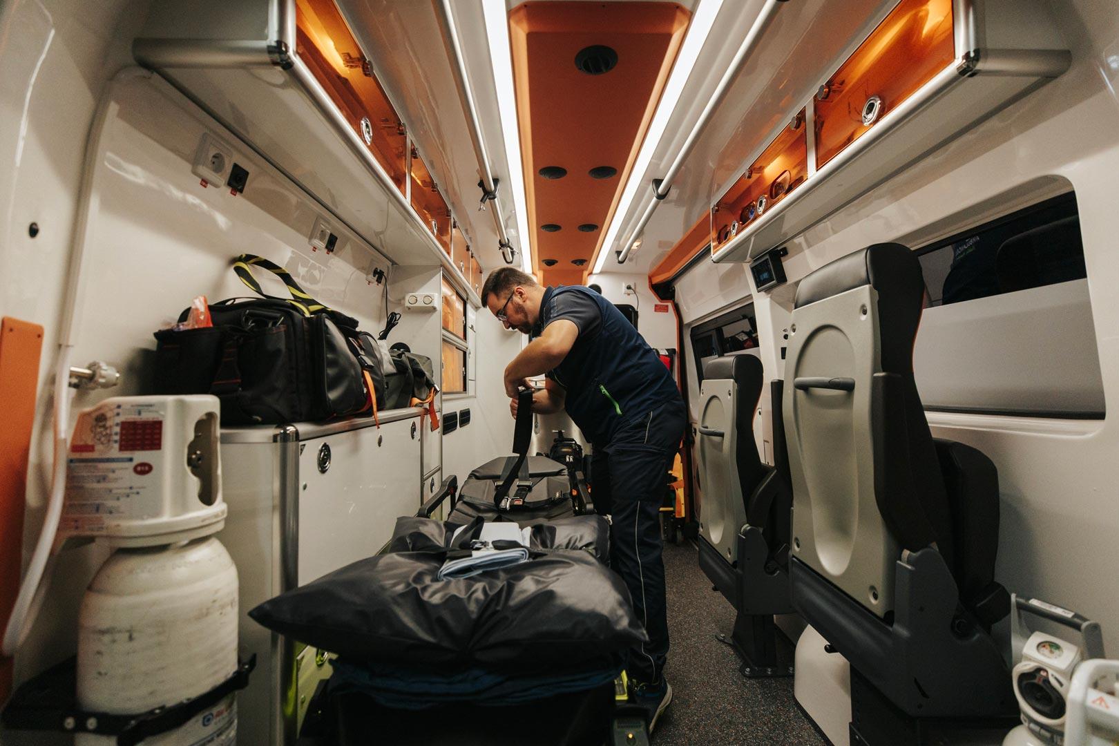 Personne exerçant son métier d'ambulancier préparant du matériel pour le transport d'un patient dans une ambulance de Bellegarde Ambulances pour une intervention dans l'Ain ou la Haute-Savoie